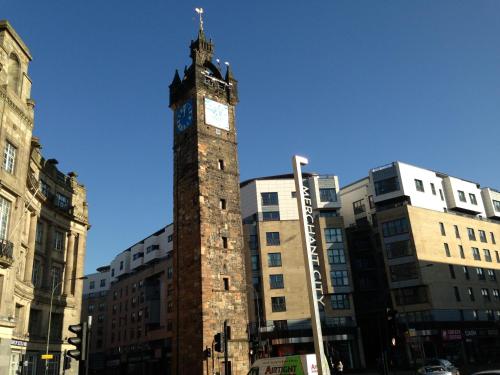 a tall clock tower in a city with buildings at Principal Apartments - Merchant City in Glasgow