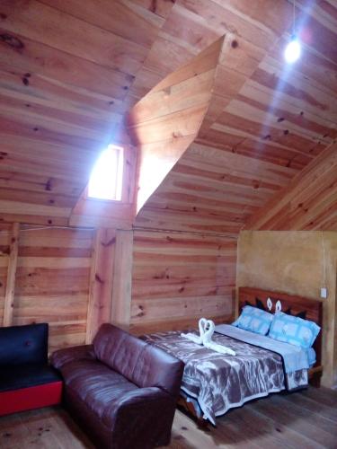 a room with a bed and a couch in a cabin at Cabañas Islas de Tziscao in Santiago