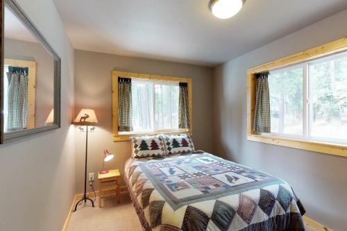 a bedroom with a bed and two windows at Peaceful Pines in Plain
