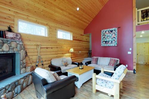 a living room with a fireplace in a log cabin at Peaceful Pines in Plain