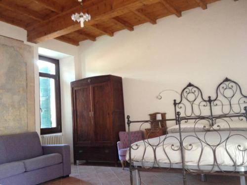ein Schlafzimmer mit einem Bett und einem Sofa in der Unterkunft Casa Clerici - Cà del merican in Nonio
