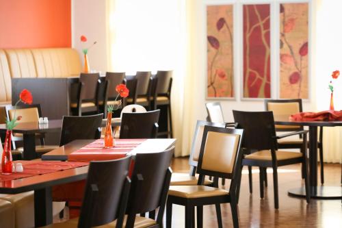a dining room with tables and chairs with red table cloth at Johanniter Gästehaus in Münster