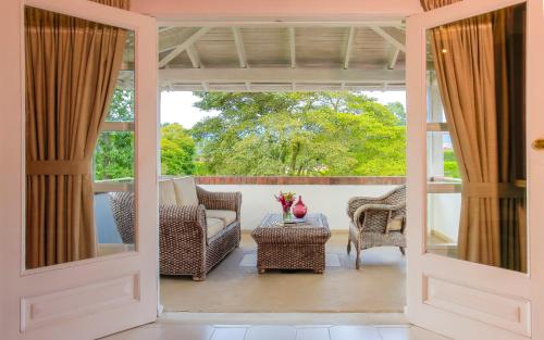 a screened in porch with a couch and chairs at Hotel Boutique El Triángulo in Armenia