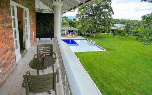 a balcony with a table and chairs and a pool at Hotel Boutique El Triángulo in Armenia