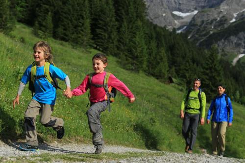 a group of children running on a mountain trail at Alp-Chalet in Hirschegg