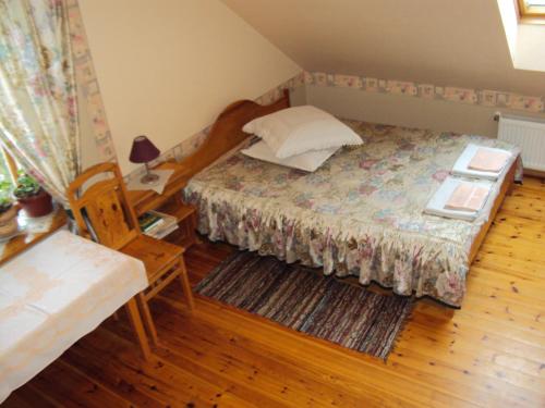 a bedroom with a bed and a table with a lamp at Saule in Talsi