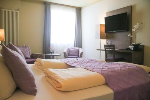
a hotel room with two beds and a television at Boutique Hotel zur Post in Vohburg an der Donau
