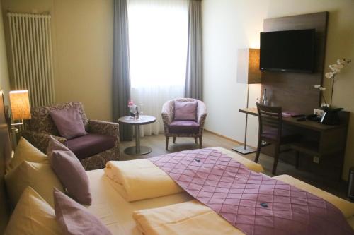 a hotel room with a bed and a living room at Boutique Hotel zur Post in Vohburg an der Donau