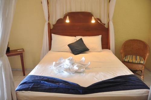 ein Bett mit zwei weißen Lilien drauf in der Unterkunft Pousada Azul Marinho in Canoa Quebrada