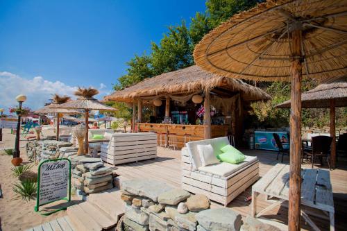 a patio with chairs and an umbrella and a bar at Hotel Palace Marina Dinevi in Sveti Vlas