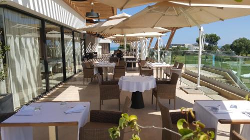 a restaurant with tables and chairs and umbrellas at Bahia Golf Beach Apartement in Bouznika