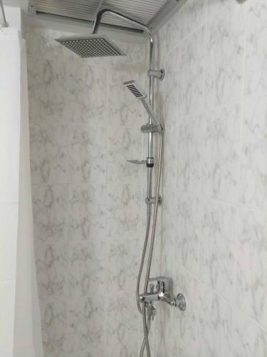 a shower with a shower head in a bathroom at SimOtel Ermis in Hanioti