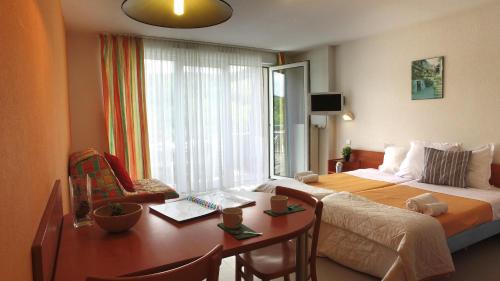 1 dormitorio con cama, escritorio y ventana en VVF Alsace Orbey Colmar, en Orbey