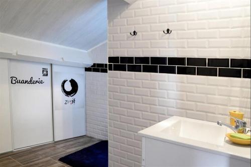 ベジエにあるBeziers Studio Terrasseの白いシンクと黒いタイルのバスルーム
