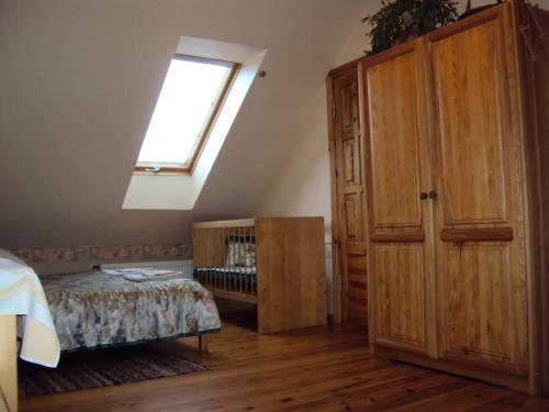 a bedroom with a bed and a window and a wooden cabinet at Saule in Talsi