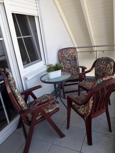 a group of chairs and a table on a porch at Ferienwohnung Gogelhopf in Unterschneidheim