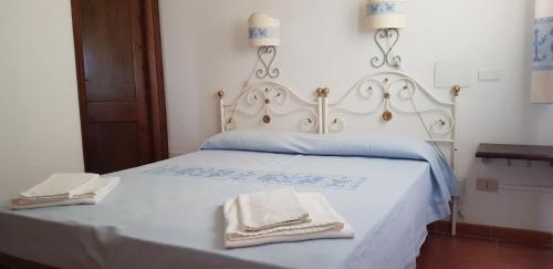 a white bed with two towels on top of it at Residence Spiaggia Bianca in Golfo Aranci
