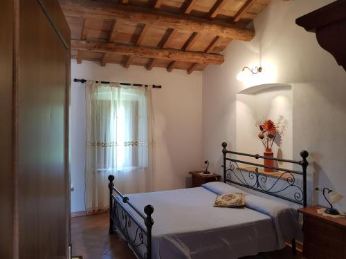 a bedroom with a bed in a room with a window at Agriturismo Bio Le 4 Stagioni in Porrona