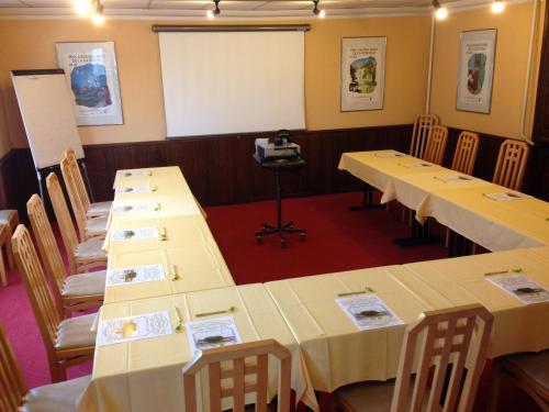 a row of tables in a room with a whiteboard at Logis Hôtel Restaurant Du Lion D'argent Et Des Tanneries in La Châtre