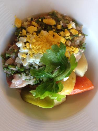 a white plate with a salad with parsley on it at Logis Hôtel Restaurant Du Lion D'argent Et Des Tanneries in La Châtre