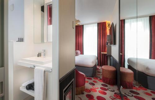 a hotel room with a bathroom with a sink and a mirror at Hotel Du Cadran in Paris