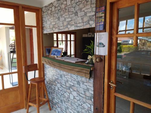 a stone wall with a bar with a laptop on it at Posada Cavieres Wine Farm in Maipú