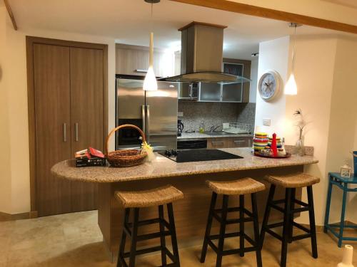 a kitchen with a large island with bar stools at Marbella Apartment Juan Dolio in Juan Dolio