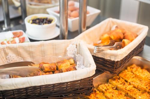 two baskets of food with utensils on a table at Oasis Hotel in Perama