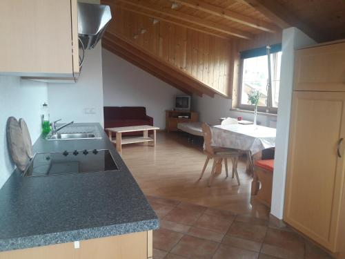 eine Küche und ein Wohnzimmer mit einem Waschbecken und einem Tisch in der Unterkunft Hofschank Reinalterhof in Mals im Vinschgau