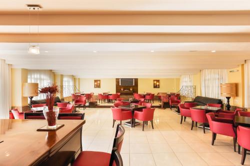 a restaurant with red chairs and tables at Oasis Hotel in Perama