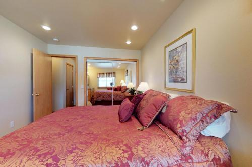 um quarto com uma cama grande com lençóis e almofadas vermelhas em Coast Haven em Port Orford