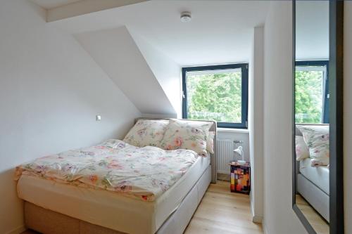 a small bedroom with a bed and two windows at FeWo Kröger in Trier