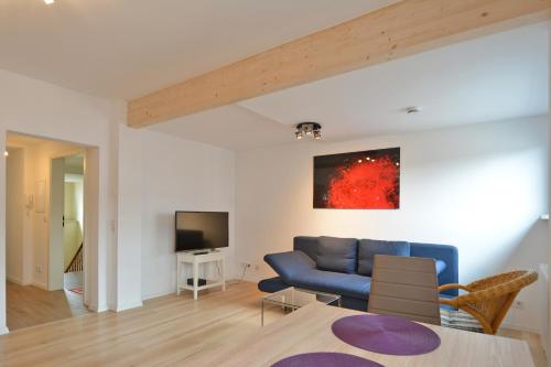 a living room with a blue couch and a tv at FeWo Kröger in Trier