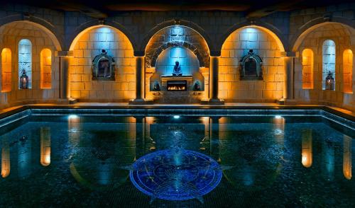 una piscina de agua en un edificio con una persona en el agua en Seraphim Cave Suites & SPA, en Ürgüp