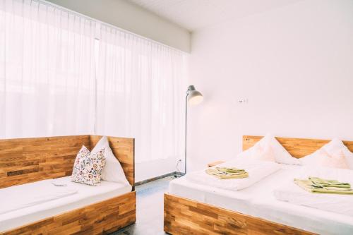due letti in una stanza con pareti bianche e una finestra di Amtshaus Gut Hügle Boutique Apartments a Bad Waldsee