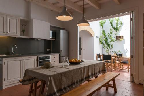 una cocina con una mesa con un bol de fruta. en Cal Bisbe, en Ciutadella