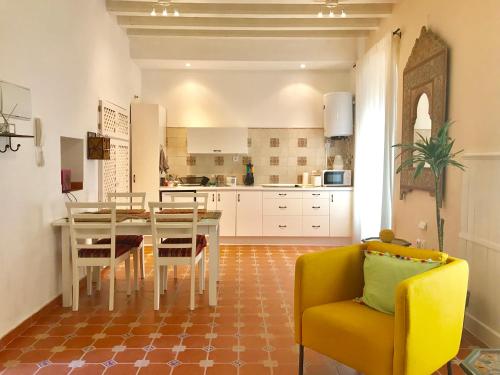 una cucina con tavolo da pranzo e sedia gialla di Casa Seven Jerez a Jerez de la Frontera