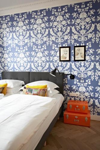 a bedroom with two beds and blue and white wallpaper at Villa Adélaïde in Chimay