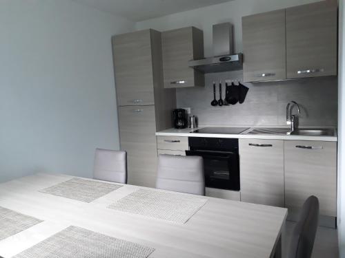 una cucina con tavolo, lavandino e piano cottura di Appartamento Chiara a Ledro