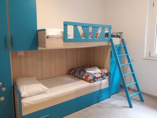 a blue bunk bed with a ladder in a room at Appartamento Chiara in Ledro