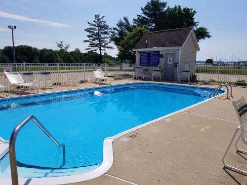 a swimming pool with chairs and a house at Mariner's Village Resort in Carlyle