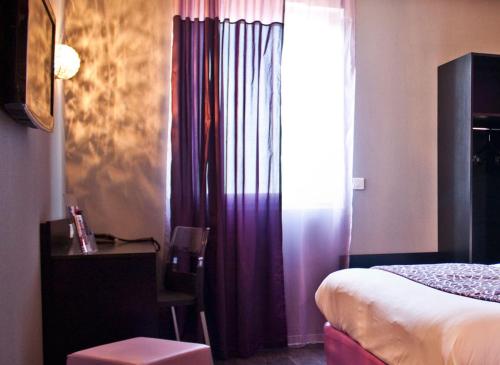 a bedroom with a bed and a window with purple curtains at The Originals City, Hôtel des Lys, Dreux in Dreux