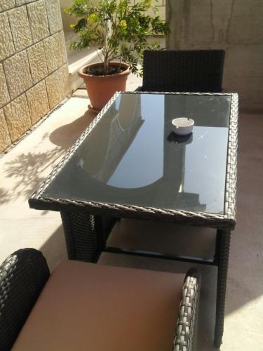 a glass table and chairs on a patio at Apartments Jerica in Bol