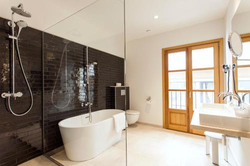 a bathroom with a tub, toilet and sink at Hotel Bosch Boutique in Palma de Mallorca