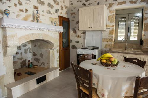 a kitchen with a table with a bowl of fruit on it at Sitia Balcony View in Sitia