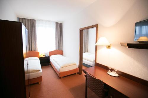 a hotel room with a bed and a mirror at Rabes Hotel Kiel in Kiel