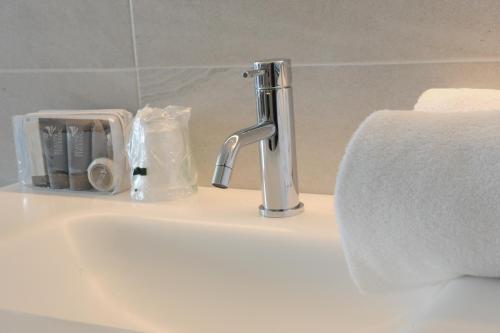 a bathroom sink with a faucet and towels on it at Park Hotel Val Di Monte ***S in Malcesine