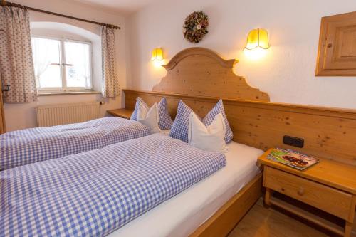 a bedroom with two beds with blue and white pillows at Schwabenbauernhof-Tradition und Moderne erleben in Ruhpolding