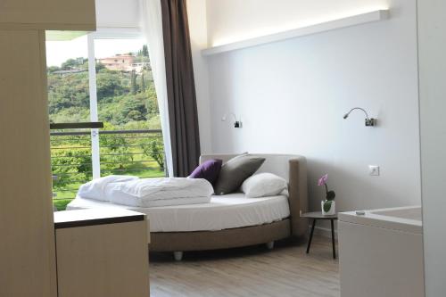 a bedroom with a bed and a large window at Park Hotel Val Di Monte ***S in Malcesine