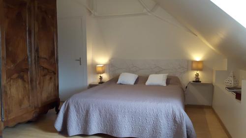 a bedroom with a bed with two white pillows at la noue aubert in Juigné-sur-Loire